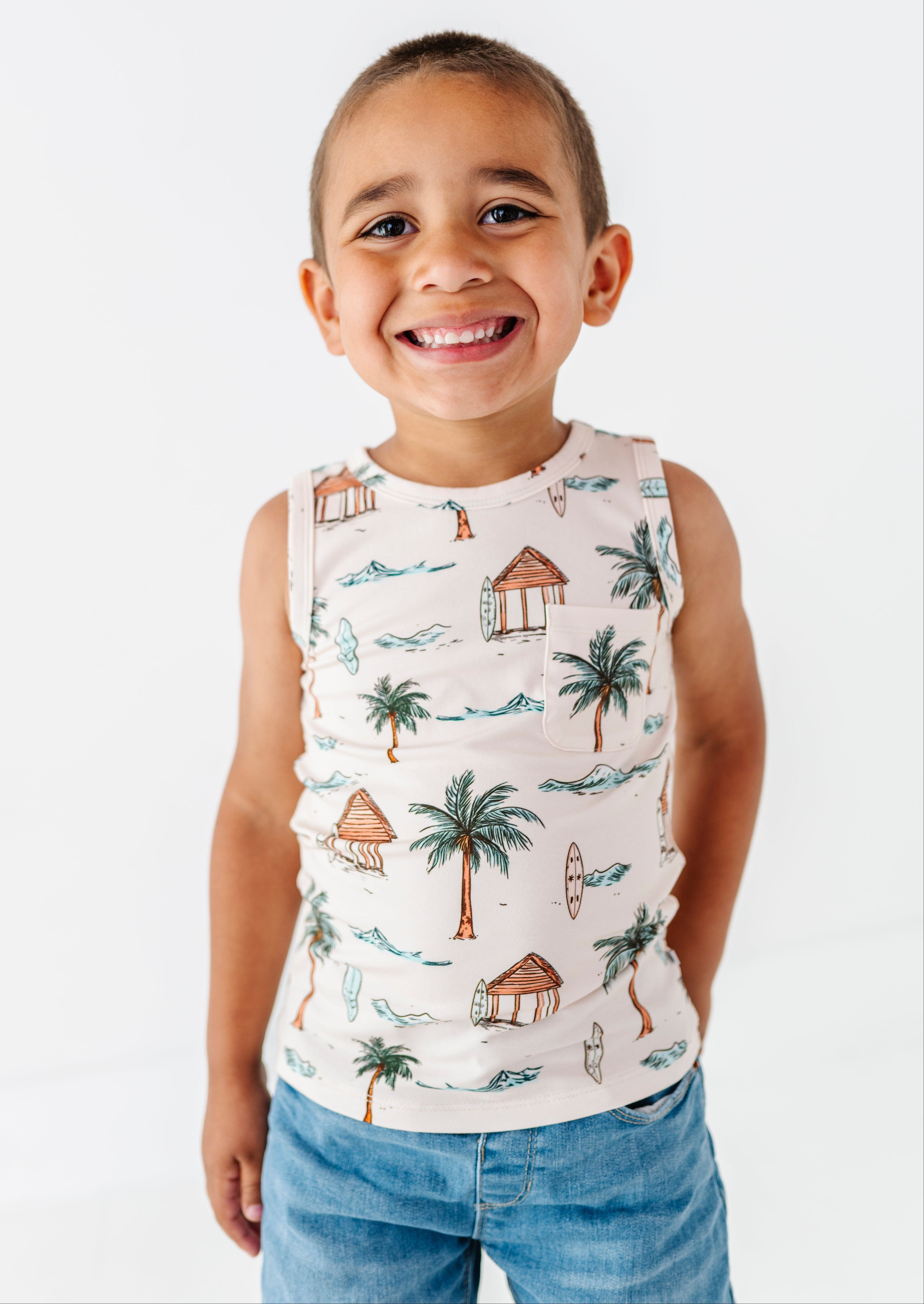 Child wearing a sleeveless shirt with tropical print on a white background